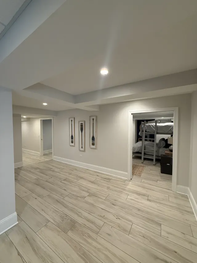 Finished basement hallway with recessed lights leading to a bunk room