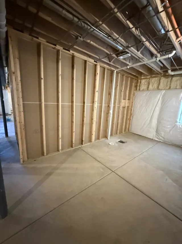 Basement bedroom walls framed and insulated before drywall
